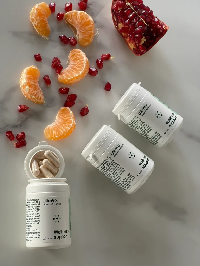 Capsule UltraVix accanto a mandarino e melograno ricchi di vitamina C